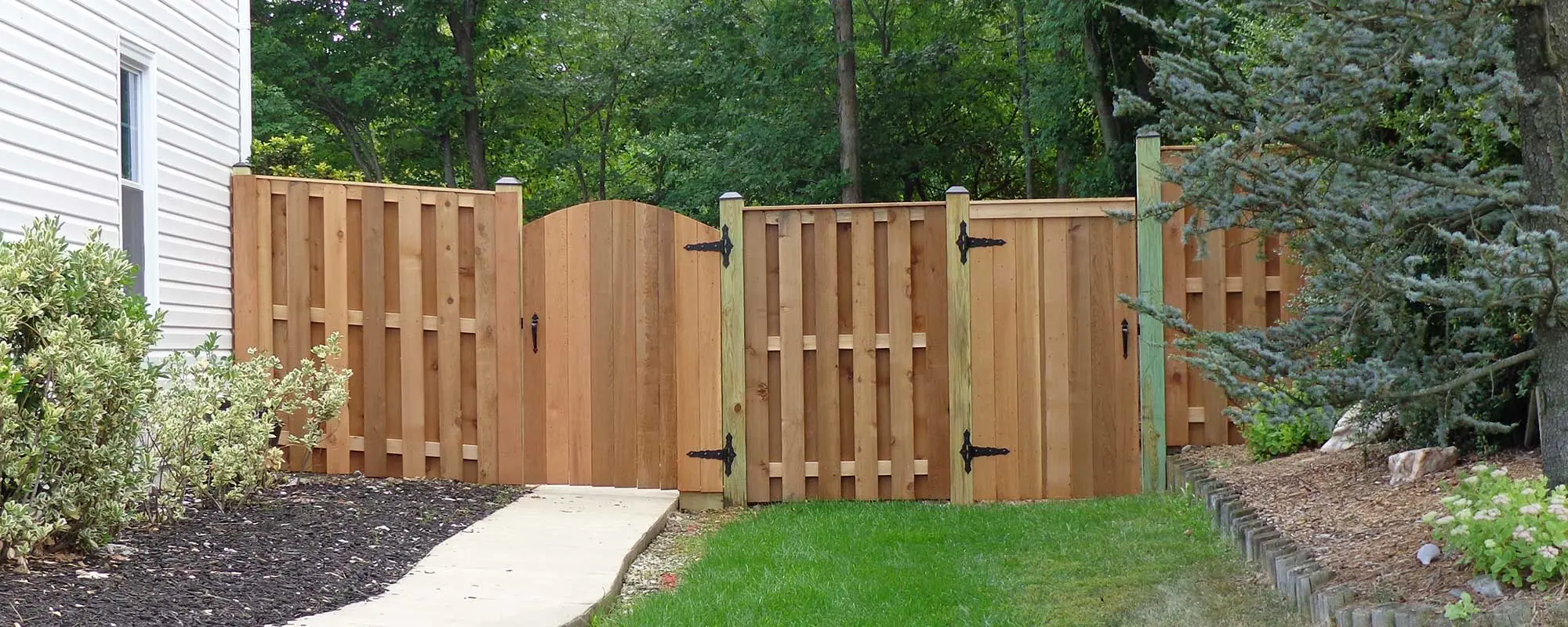 Custom wood fence installed with two entry gates